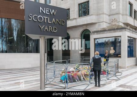 April. Zehn Tage nach dem Terroranschlag in Westminster halten die Menschen immer noch an, um die Blumen für die Opfer zu sehen und zu fotografieren. Vor dem New Scotland Yard Neubau an der Victoria Embankmen befindet sich ein Bereich mit Blumen zum Gedenken an PC Keith Palmer. Stockfoto