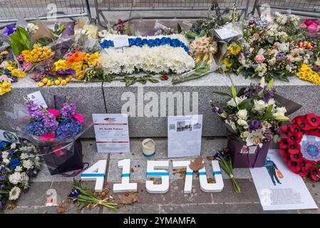 April. Zehn Tage nach dem Terroranschlag in Westminster halten die Menschen immer noch an, um die Blumen für die Opfer zu sehen und zu fotografieren. Vor dem New Scotland Yard Neubau an der Victoria Embankmen befindet sich ein Bereich mit Blumen zum Gedenken an PC Keith Palmer. Mehrere Tribute enthalten eine „dünne blaue Linie“. Stockfoto