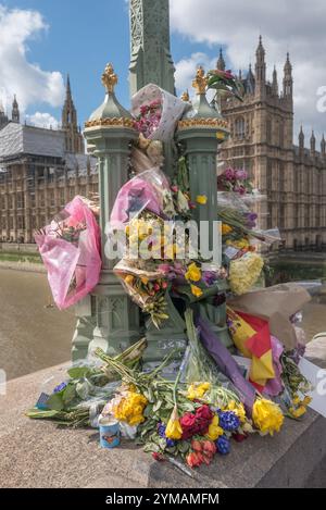 April. Zehn Tage nach dem Terroranschlag in Westminster halten die Menschen immer noch an, um die Blumen für die Opfer rund um die Lampenstandards auf der Waterloo Bridge zu sehen und zu fotografieren. Stockfoto