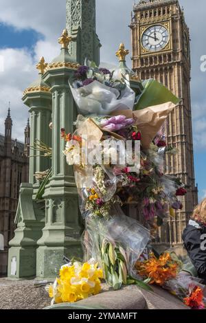 April. Zehn Tage nach dem Terroranschlag in Westminster halten die Menschen immer noch an, um die Blumen für die Opfer rund um die Lampenstandards auf der Waterloo Bridge zu sehen und zu fotografieren. Stockfoto