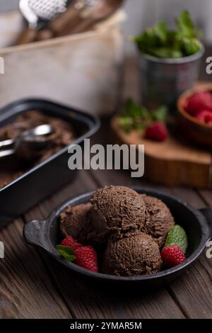 Hausgemachte Schokoladen-Eiskugeln mit Himbeeren und Minze Stockfoto