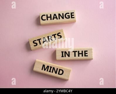 Veränderung beginnt im Gedankensymbol. Konzeptworte Veränderung beginnt im Geist auf Holzblöcken. Schöner rosafarbener Hintergrund. Business und Change beginnen in t Stockfoto