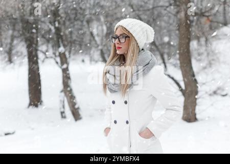 Winterporträt der schönen blonden Frau mit Brille im Park. Stockfoto