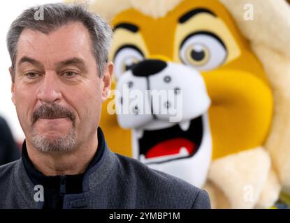 München, Deutschland. November 2024. Markus Söder (CSU), Ministerpräsident Bayerns, besucht die Infanteriestraße und stellt den neuen Radfahrschein vor. Hinter Söder steht das Maskottchen der bayerischen Landesregierung. Er begleitet die Schüler während ihrer Grundschulzeit. Ziel ist es, dass Kinder sicher auf der Straße fahren, Gefahren erkennen und Unfälle so weit wie möglich vermeiden können. Quelle: Sven Hoppe/dpa/Alamy Live News Stockfoto