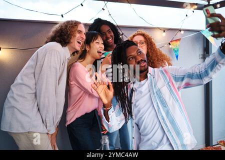 Multiethnische Freunde machen ein Selfie auf der Dachparty Stockfoto