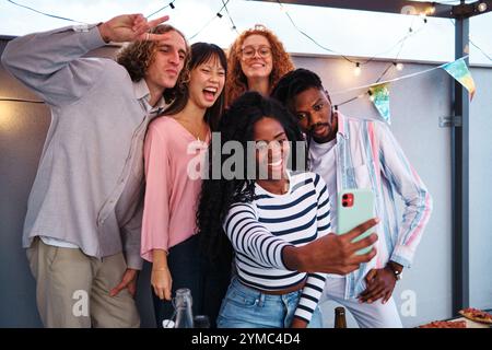 Multiethnische Freunde machen Selfie auf der Dachparty Stockfoto