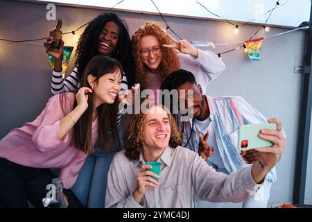 Multiethnische Freunde machen ein Selfie auf der Dachparty Stockfoto