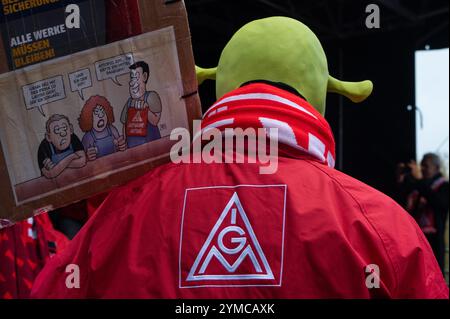 Wolfsburg, Deutschland. November 2024. Ein Volkswagen-Mitarbeiter mit Shrek-Maske demonstriert vor der Volkswagen Arena in Wolfsburg während der Tarifverhandlungen zwischen Volkswagen und IG Metall. Die IG Metall begrüßt die Konzernvertreter zur dritten Tarifrunde mit lautem Protest. Tausende Teilnehmer demonstrieren vor dem Werk am Verhandlungsort in der Volkswagen Arena, gefolgt von einer Protestkundgebung direkt vor dem Stadion. Quelle: Alicia Windzio/dpa/Alamy Live News Stockfoto