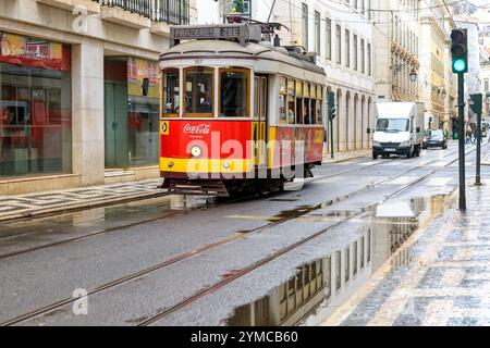 Lissabon, Portugal - 10. November 2024: Eine traditionelle Straßenbahn fährt auf einer Stadtstraße in der Altstadt. Stockfoto