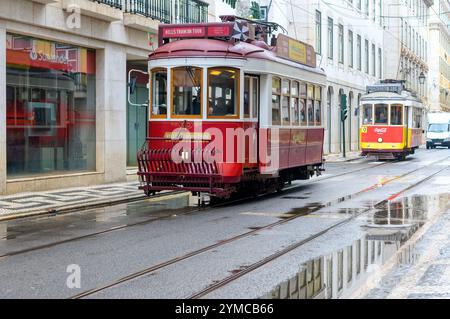 Lissabon, Portugal - 10. November 2024: Eine traditionelle Straßenbahn fährt auf einer Stadtstraße in der Altstadt. Stockfoto