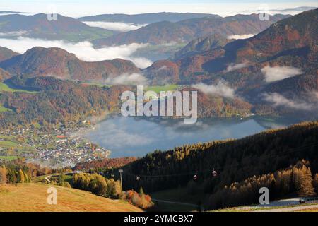 Panoramablick vom Zwolferhorn auf den nebeligen Wolfgangsee, die umliegenden Berge und St. Gilgen, Salzkammergut, Steiermark, Österreich, Europa Stockfoto