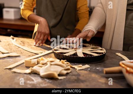 Oma und asiatische Teenagerin backen zusammen Kuchen, zu Hause Stockfoto