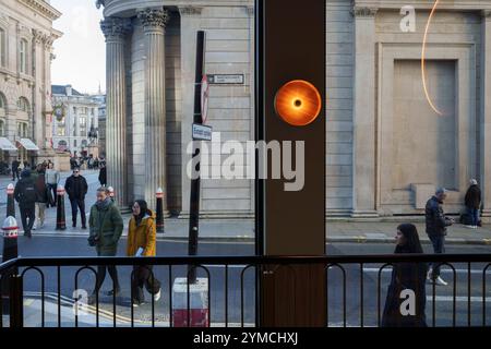 Stadtarbeiter gehen am 20. November 2024 über die Ecke Threadneedle Street und Batholomew Lane, wo die Mauern und Säulen der Bank of England rechts in der City of London, dem Finanzviertel der Hauptstadt, zu sehen sind. Stockfoto