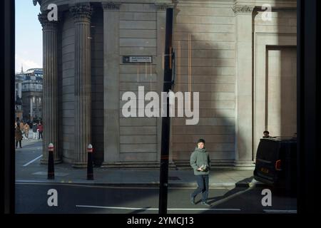 Stadtarbeiter gehen am 20. November 2024 über die Ecke Threadneedle Street und Batholomew Lane, wo die Mauern und Säulen der Bank of England rechts in der City of London, dem Finanzviertel der Hauptstadt, zu sehen sind. Stockfoto