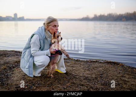 Frau mit Yorkshire Terrier am Seeufer Stockfoto