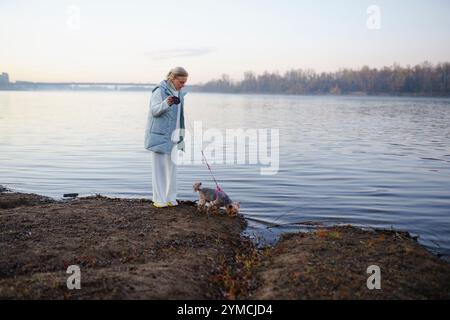 Frau mit Yorkshire Terrier am Seeufer Stockfoto