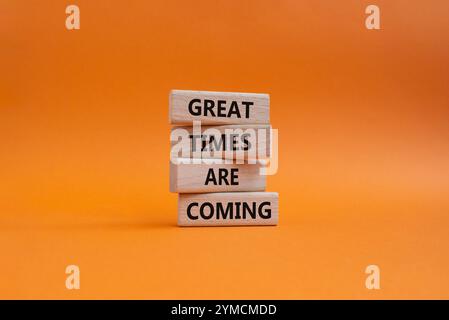 Große Zeiten werden bald Symbol. Concept Words tolle Zeiten kommen auf Holzblöcken. Wunderschöner orangefarbener Hintergrund. Das Geschäft und die großartigen Zeiten kommen Stockfoto