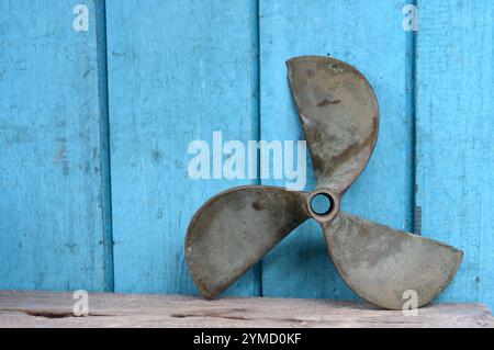 Alte Metall Propeller von Schiffen, die in der blauen Holzwand Stockfoto