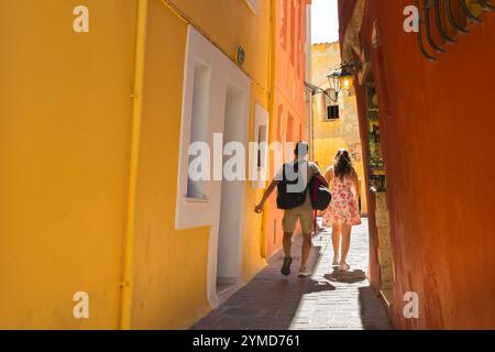 Junges Paar, Rückansicht von jungen Menschen, die durch eine bunte enge Straße in der malerischen Altstadt von Chania (Hania), Kreta, Griechenland laufen Stockfoto