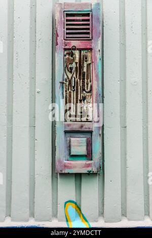 An einer Wand neben dem Aruba-Viadukt in Willemstad hängen Collagen von Sammlergegenständen aus Curacao, alle signiert TOPO 13, unauffällig an ausgemusterten Fensterrahmen. Willemstad, Curacao, Kòrsou Stockfoto