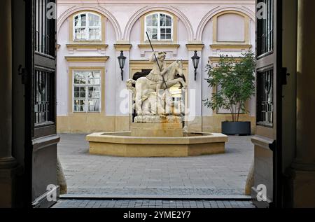 Ein Brunnen mit einer Statue, die den Heiligen Georg beim Erlegen eines Drachen darstellt, steht in einem Innenhof des historischen Primatenpalastes von Bratislava. Stockfoto