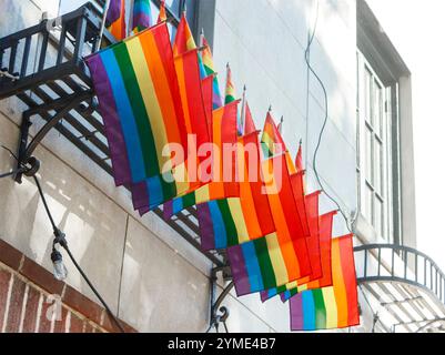 Mehrere Regenbogenfahnen hängen an der Feuertreppe im Stonewall Inn, wo im Greenwich Village New York in den 1960er Jahren berühmte Unruhen um die Rechte der Schwulen stattfanden Stockfoto