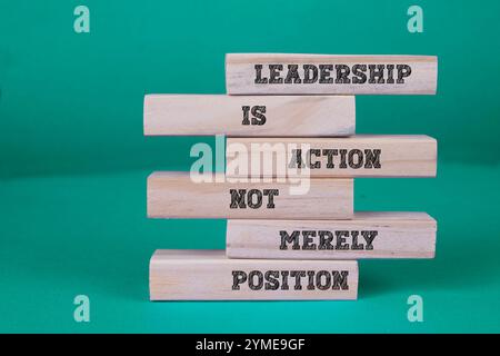 Holzblöcke mit den Worten „Führung ist Aktion, nicht Position. Lebenskonzept, Geschäftskonzept, Lebensweise Stockfoto