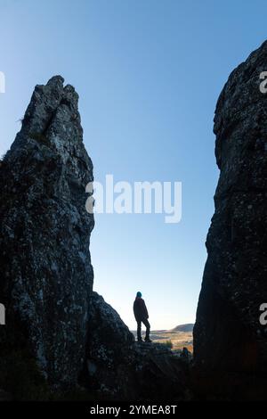 Eine Person Silhouetten im Whangie, einem Steinkorridor, der sich über fast 100 m erstreckt, mit hohen Klippen auf beiden Seiten, Auchineden Hill, Schottland Stockfoto