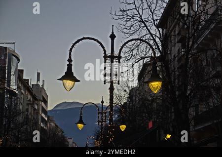 Abendlicher Blick auf eine wunderschöne Kombination aus verschiedenen Leuchten an einem Strommasten vor Neujahr, Sofia, Bulgarien Stockfoto