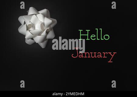 Die weiße Schleife ist auf schwarzem Hintergrund mit den Worten Hello January in rot und grün Stockfoto