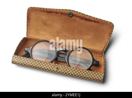 Ein Paar schwarze Brillen im braunen Ledergehäuse mit isoliertem weißem Hintergrund, klassisches Brillendesign mit rundem Rahmen und klarer Linse Stockfoto