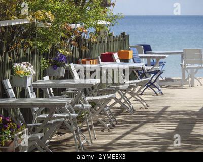 Ein gemütliches Café mit weißen und blauen Stühlen und Tischen entlang eines Weges am Meer, sopot, ostsee, polen Stockfoto