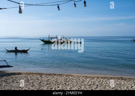 Laiya Beach, Batangas, Philippinen - 16. August 2024: Fischer, die mit dem frühen Morgencach an Land kommen. Die Menschen in den Dörfern der Küstenprovinz leben weiterhin auf traditionelle Weise Stockfoto