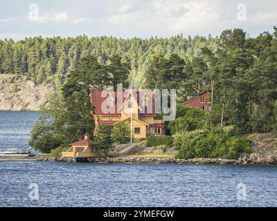 Große Villa am Wasser umgeben von dichten Bäumen und Wäldern, Archipel, stockholm, schweden Stockfoto