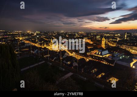 Sonnenuntergang über der Grazer Altstadt, Blick vom Schlossberg, beleuchteter Turm der Franziskanerkirche, beleuchtetes Rathaus, Dächer in der Altstadt Stockfoto