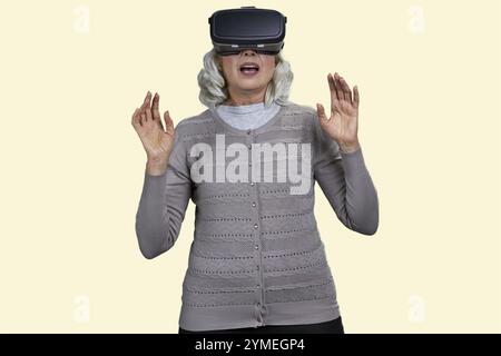 Überraschte emotional reife Frau mit Virtual-Reality-Brille. Isoliert auf weißem Hintergrund Stockfoto