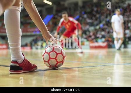 Nahaufnahme des Futsal-Balls in der Ecke und des Beins des Spielers Stockfoto