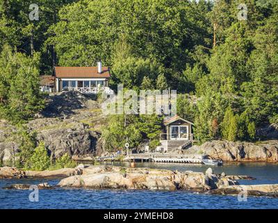 Zwei Cottages eingebettet in eine bewaldete Felsenlandschaft am See, Archipel, stockholm, schweden Stockfoto