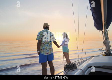 Reisen Sie mit einer Yacht um die Welt. Liebe Story. Flitterwochenreise auf einer Segelyacht. Yacht bei Sonnenuntergang. Date von Mann und Mädchen auf einer Yacht. Machen Sie einen Ausflug durch die Stockfoto