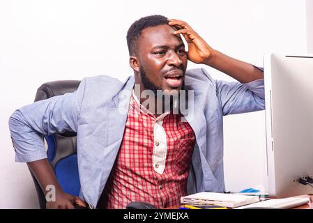 Der junge Geschäftsmann war erstaunt und überrascht, als er im Büro auf den Laptop-Bildschirm schaute. Stockfoto