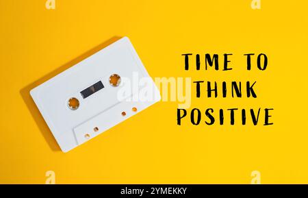 Das weiße Kassettenband ist auf gelbem Hintergrund mit der Aufschrift Time to To Think positive Stockfoto