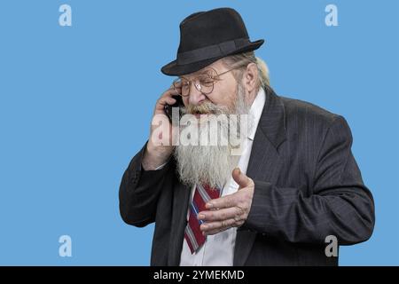 Ein alter Geschäftsmann in schwarzem Anzug, der am Telefon spricht. Isoliert auf Schwarz Stockfoto