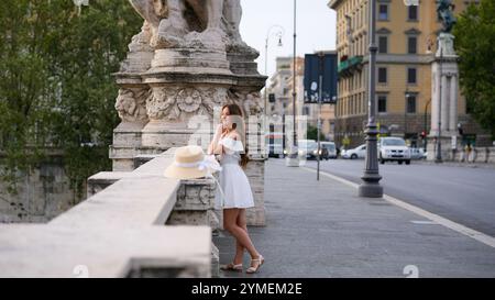 Wunderschönes Mädchen, das Architektur bewundert, während er auf einer Brücke in Rom, Italien, steht Stockfoto