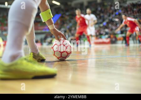 Futsal-Match - Nahaufnahme des Balls in der Ecke und Hand und Beine des Spielers. Stockfoto