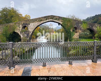 Römische Brücke mit dem Siegeskreuz, Symbol Asturiens, über den Fluss Sella in der Stadt Cangas de Onís, Asturien, Spanien Stockfoto