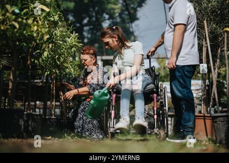 Inklusive Gartenarbeit mit älteren Frauen, Mädchen im Rollstuhl und Jungen mit Down-Syndrom Stockfoto