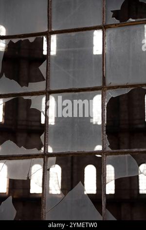 Kaputtes Fenster im alten Fabrikgebäude. Abstrakter Hintergrund und Textur für Design. Stockfoto