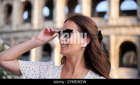 Lächelnde Reisende in Sonnenbrille genießt ihren Besuch im Kolosseum in Rom Italien Stockfoto
