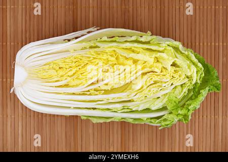 Halbierter Chinakohl mit der Seite nach oben auf einer Bambus-Tischmatte, Blick von oben auf frisch geschnittenen gesunden Kohl, Brassica rapa subsp. Pekinensis Stockfoto