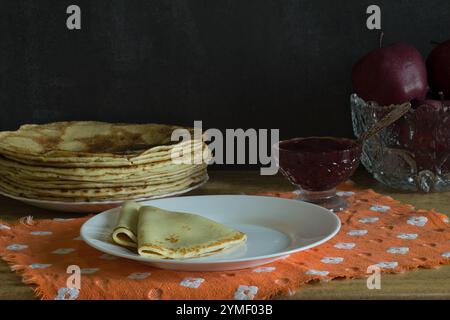 Crepes mit Marmelade und einen Teller mit Pfannkuchen auf dem Tisch Stockfoto